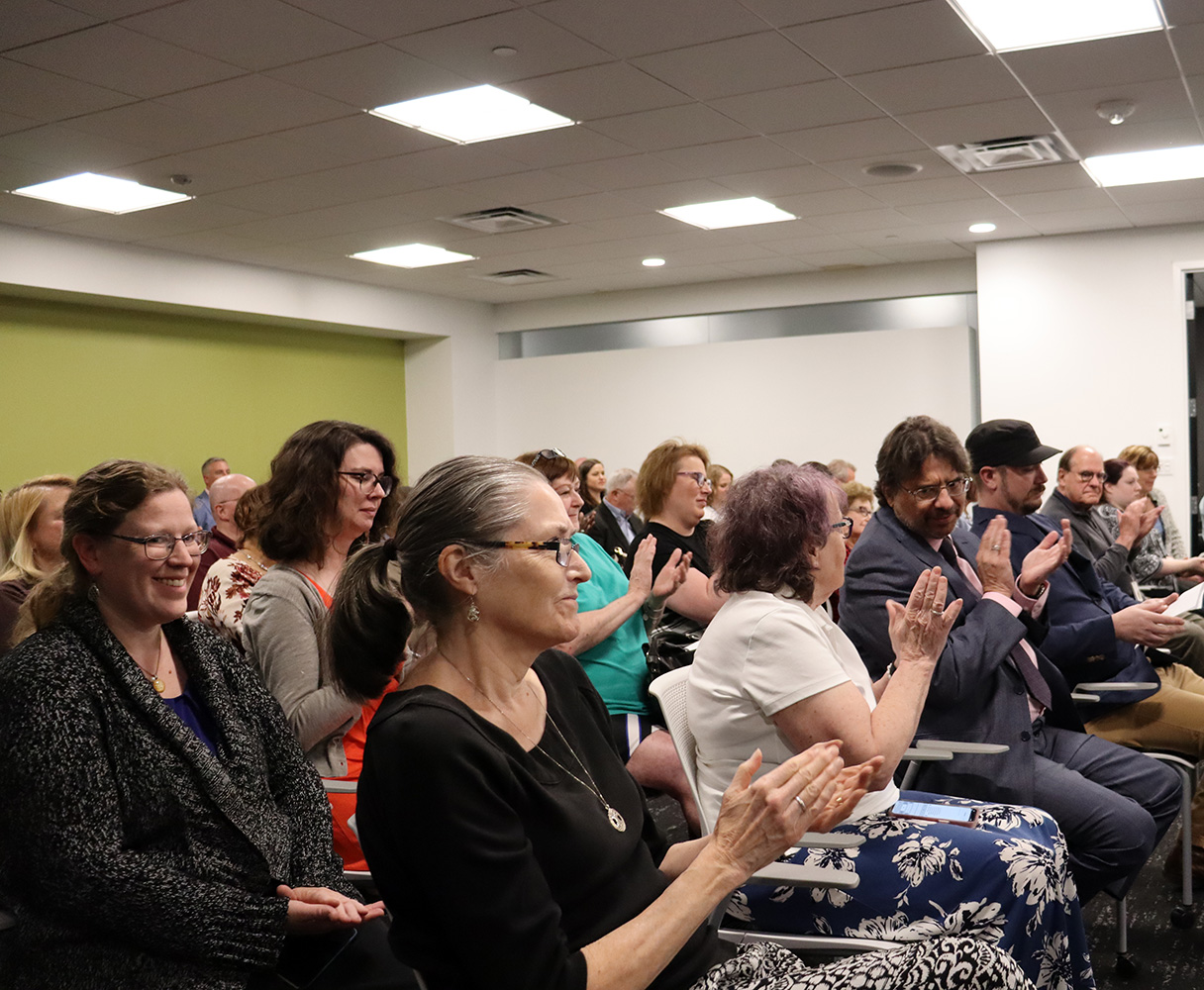 An audience in the RAD board meeting room applauds